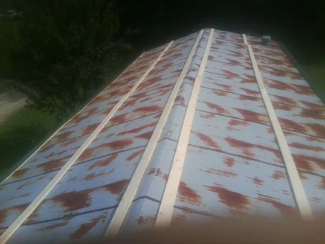 Rusted metal roof panels with new wood purlins before replacement — Storm Damage Roof Repair in New Ellenton by Roofing Brothers