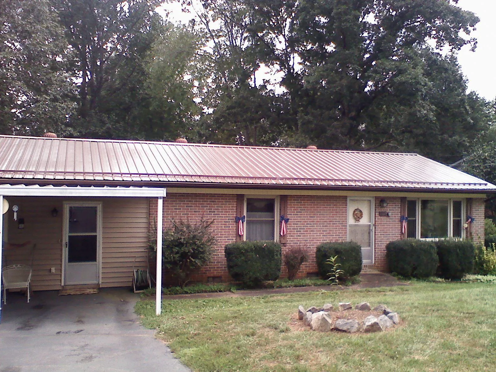 Bronze metal roof and carport on a brick ranch home — Roof Repair work by our crew in New Ellenton